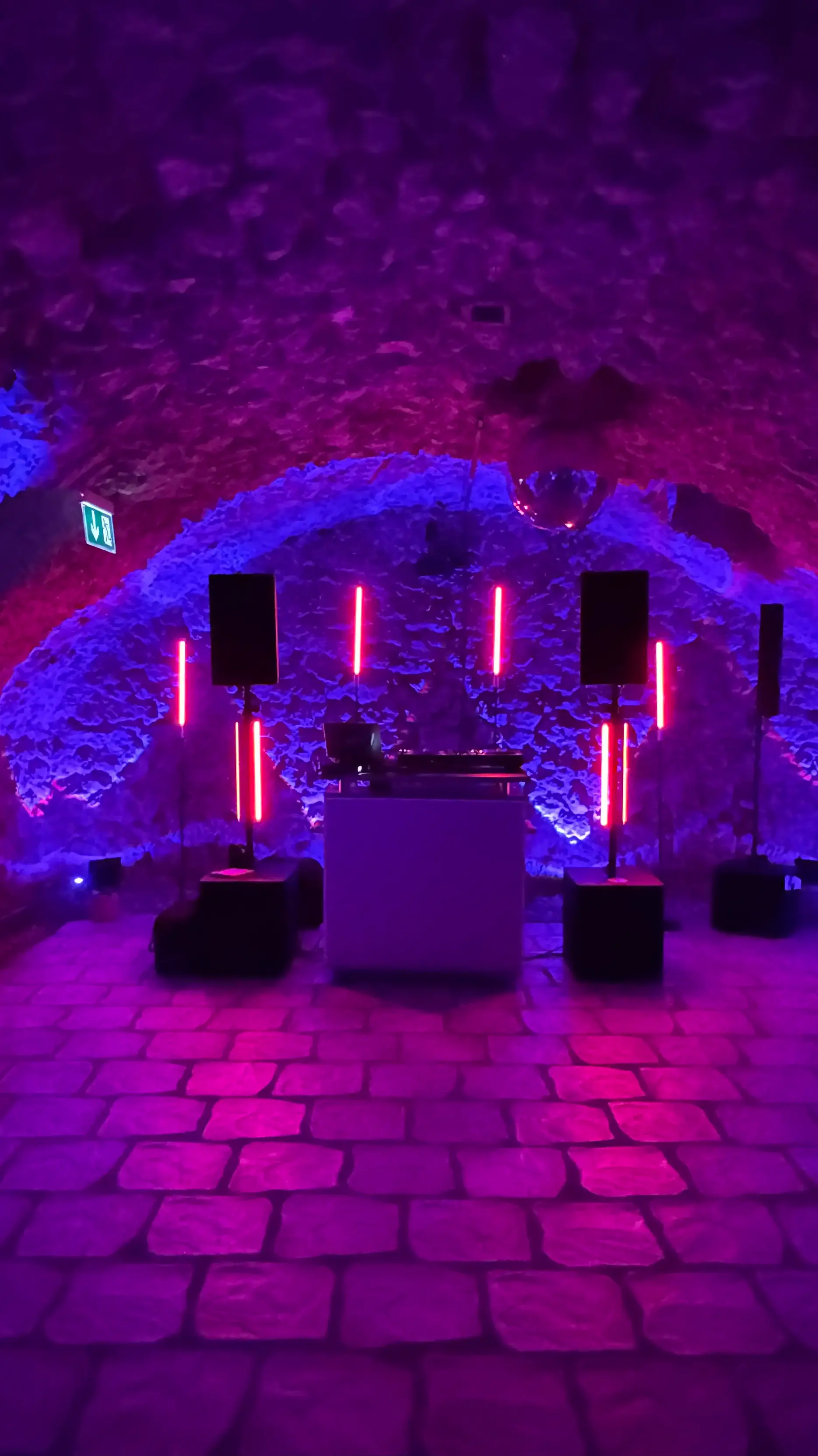 Gewölbekeller mit DJ-Pult, Lautsprechern auf Stativen und roten LED-Stelen für Veranstaltungstechnik mieten in Frankfurt.