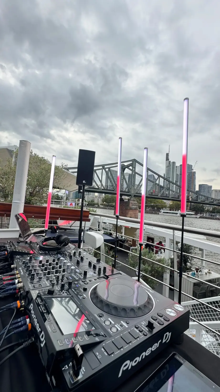 Pioneer DJ-Pult mit LED-Stelen auf einem Schiff vor der Frankfurter Skyline als Musikanlage mieten in Frankfurt.
