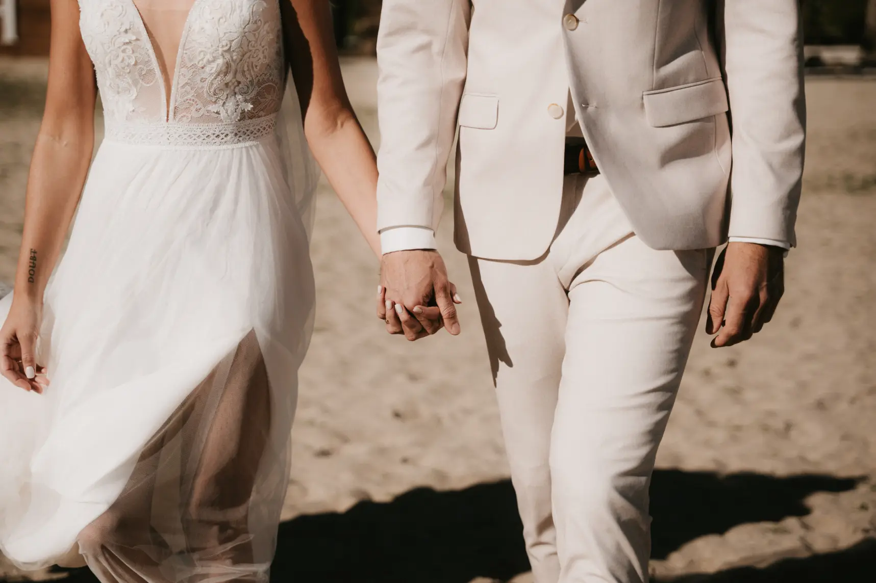 Brautpaar Hand in Hand am Strand bei einer Hochzeit, Veranstaltungstechnik mieten in Hamburg.