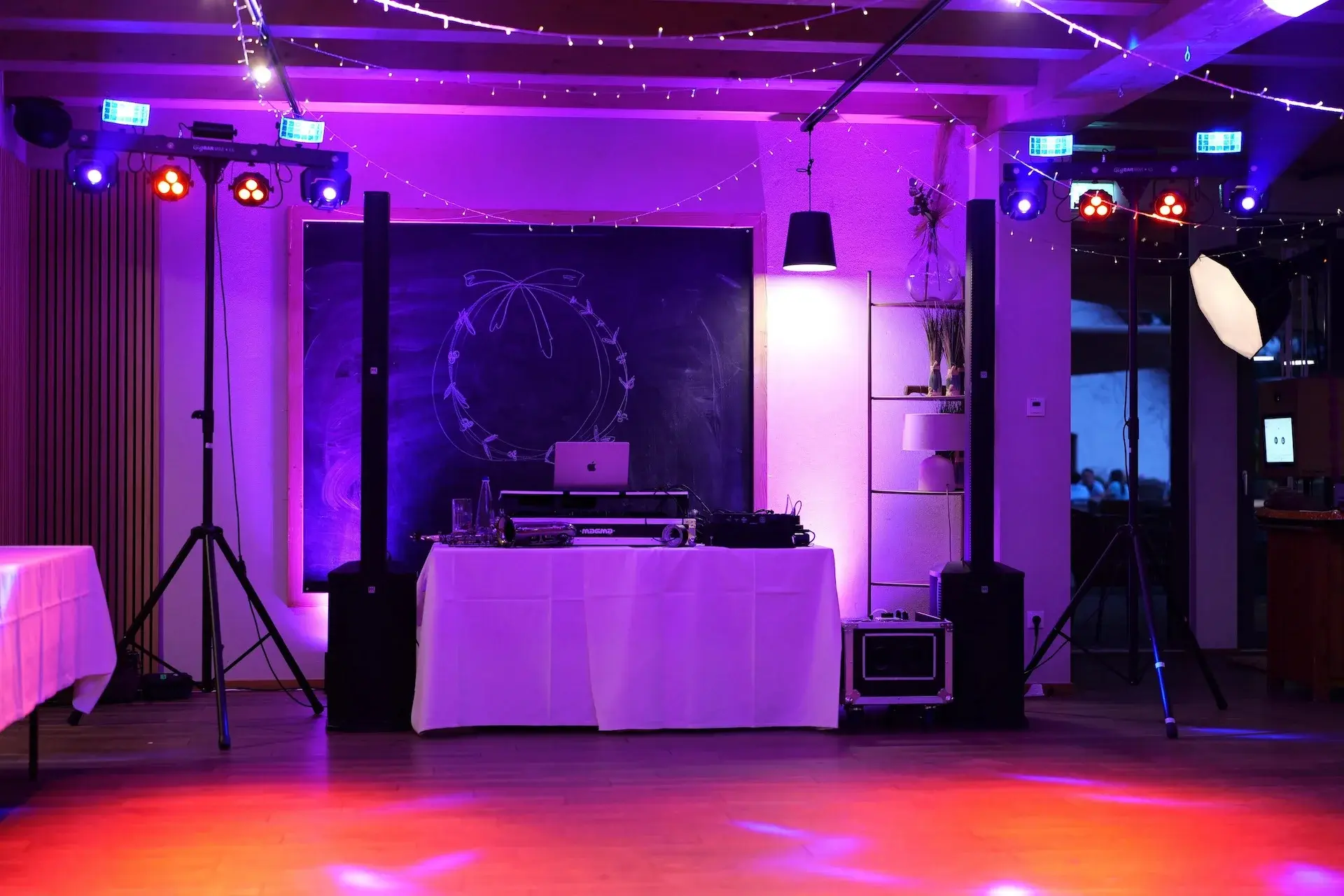 DJ-Pult vor einer Tafel mit Lichteffekten und Lautsprechern bei einer Hochzeit als Musikanlage mieten in Karlsruhe.
