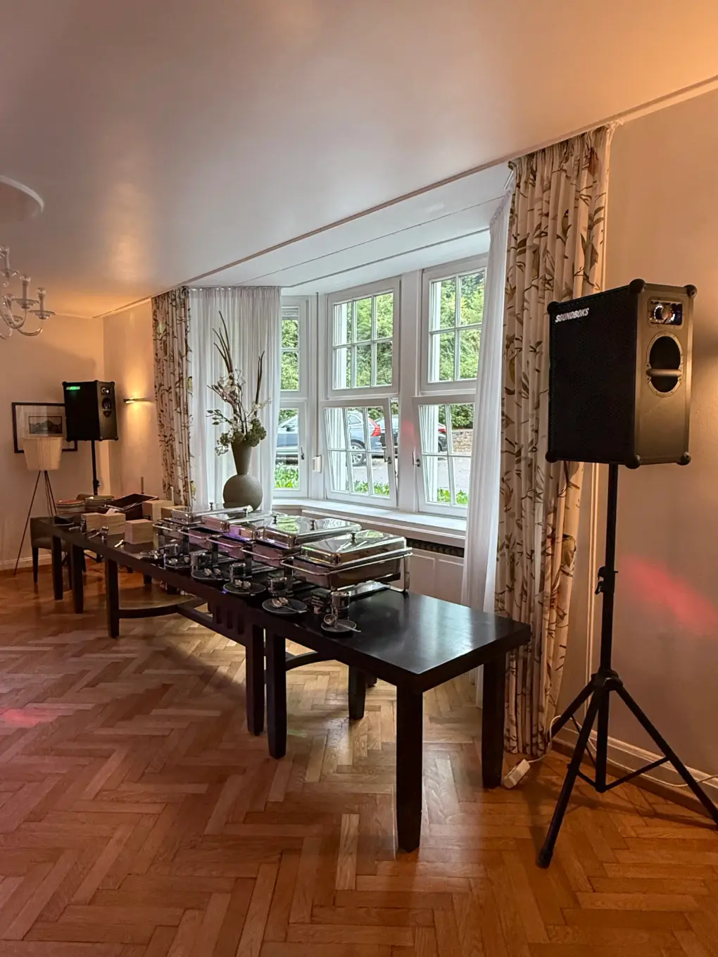 Buffet mit Chafing-Dishes und ein Lautsprecher auf Stativ am Fenster bei einer Feier für Lautsprecher mieten in Mainz.