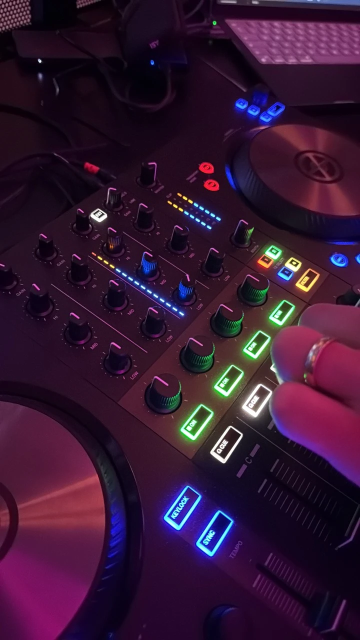 Nahaufnahme eines beleuchteten DJ-Controllers mit einer Hand am Mischpult als Musikanlage mieten in Mannheim.
