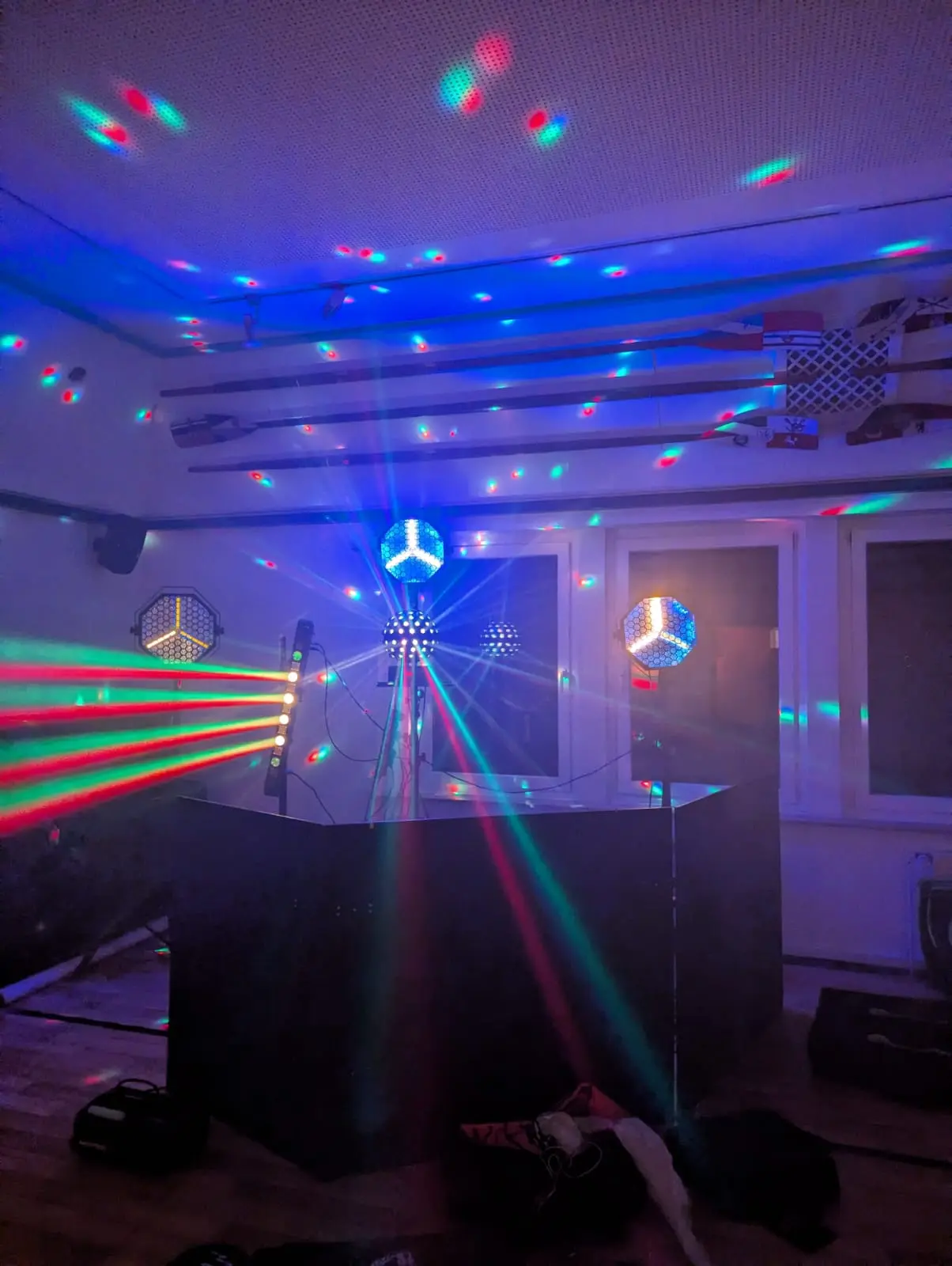 DJ-Pult mit Discokugel und bunten Lichteffekten in einem Raum als Veranstaltungstechnik mieten in Münster.
