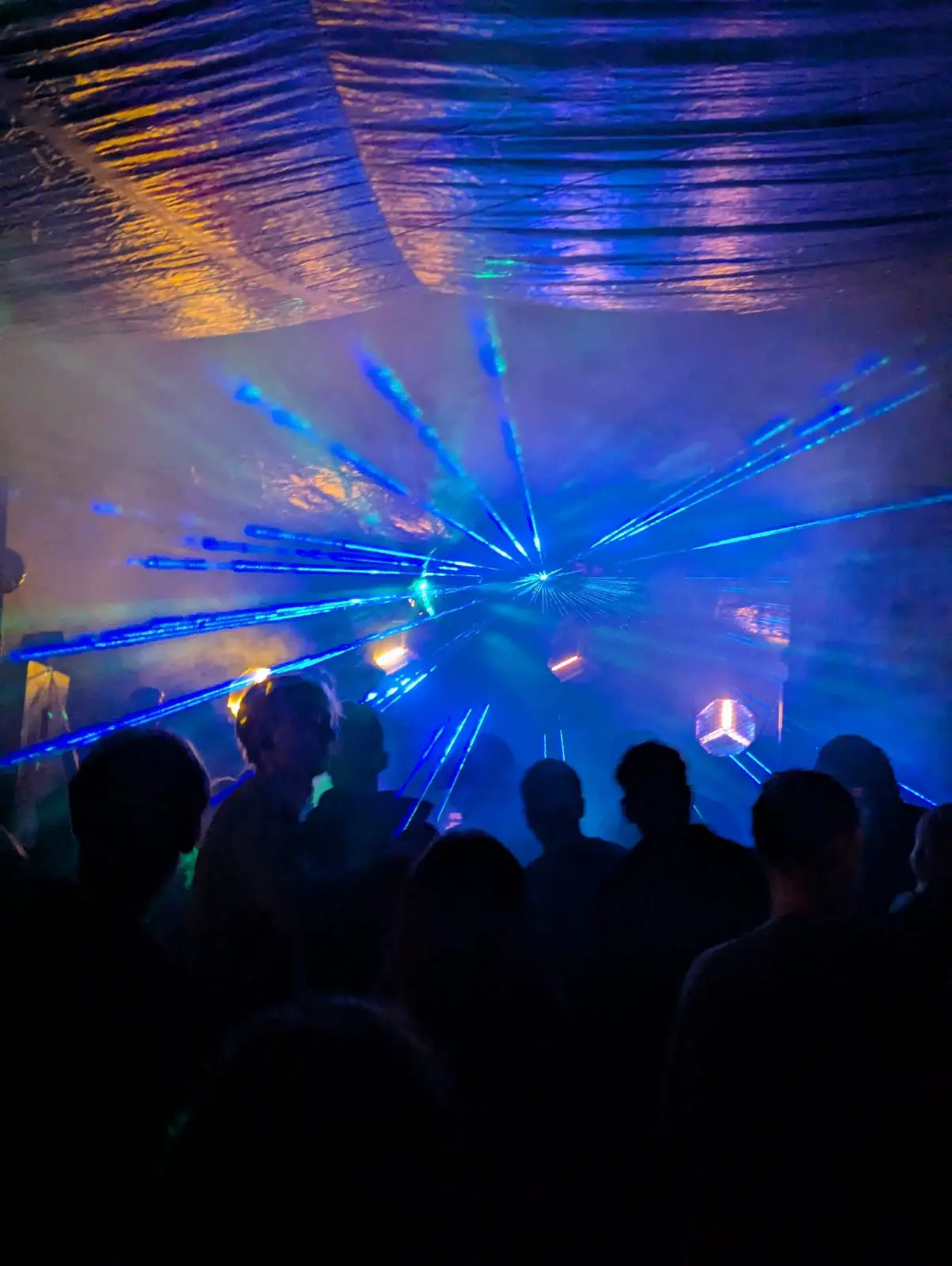 Blaue Lasereffekte über der tanzenden Menge auf einer Party für Veranstaltungstechnik mieten in Münster.