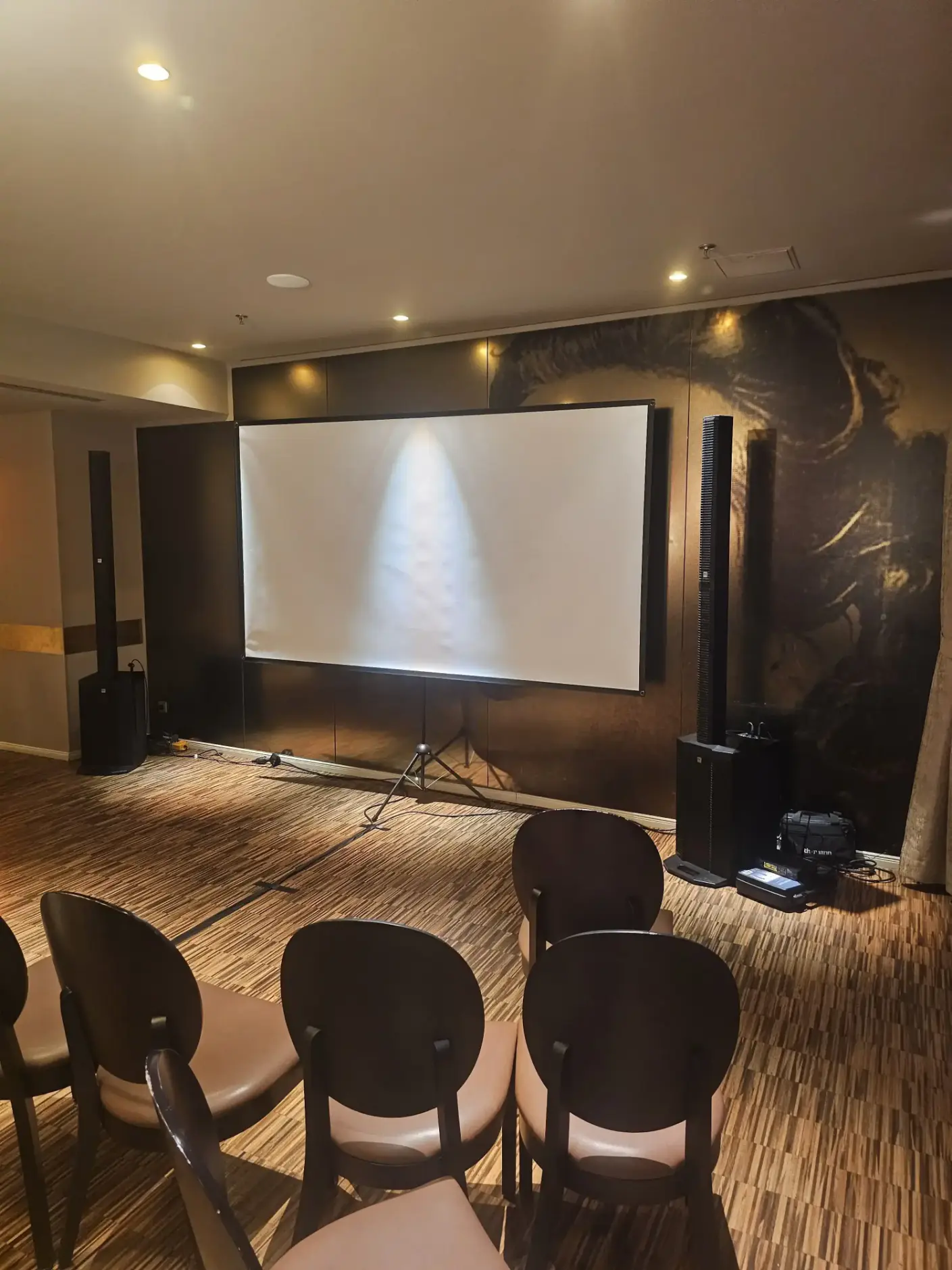 Leinwand mit Beamer, Bestuhlung und Säulenlautsprechern bei einer Präsentation, Veranstaltungstechnik mieten in Wien.