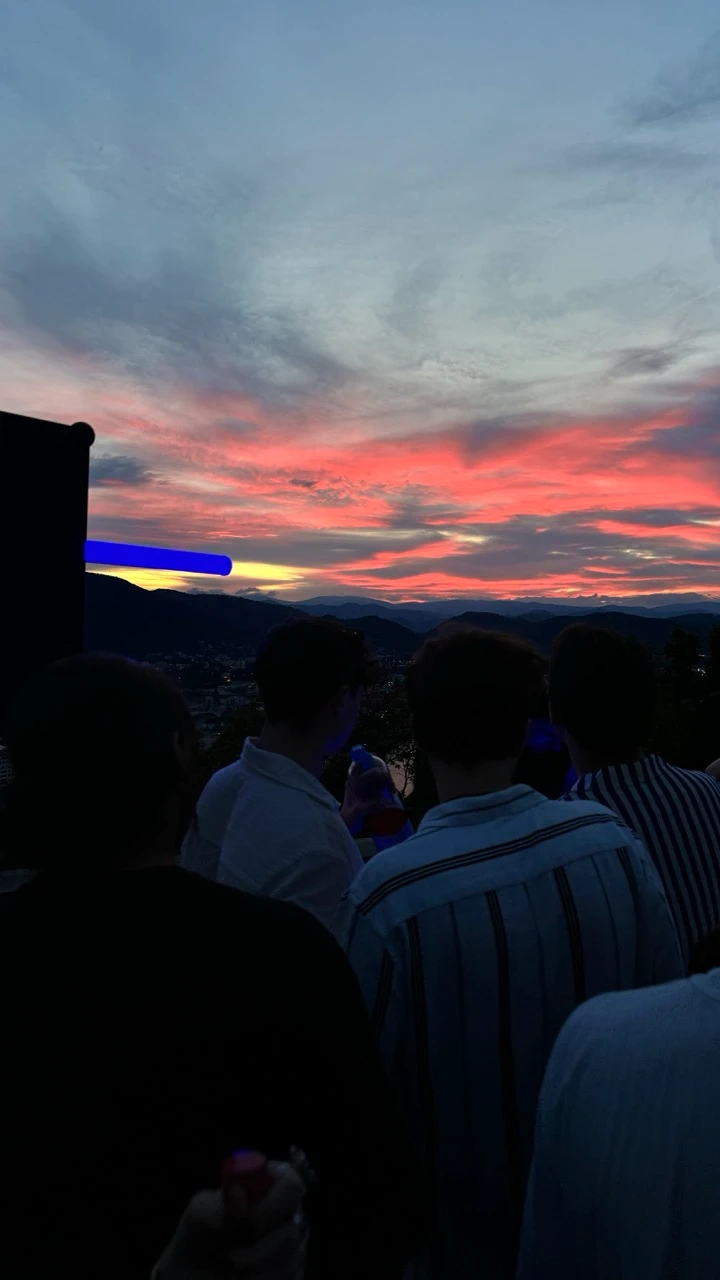 Gäste bei Sonnenuntergang auf einer Terrasse mit blauer Lichtröhre, Veranstaltungstechnik mieten in Wiesbaden.