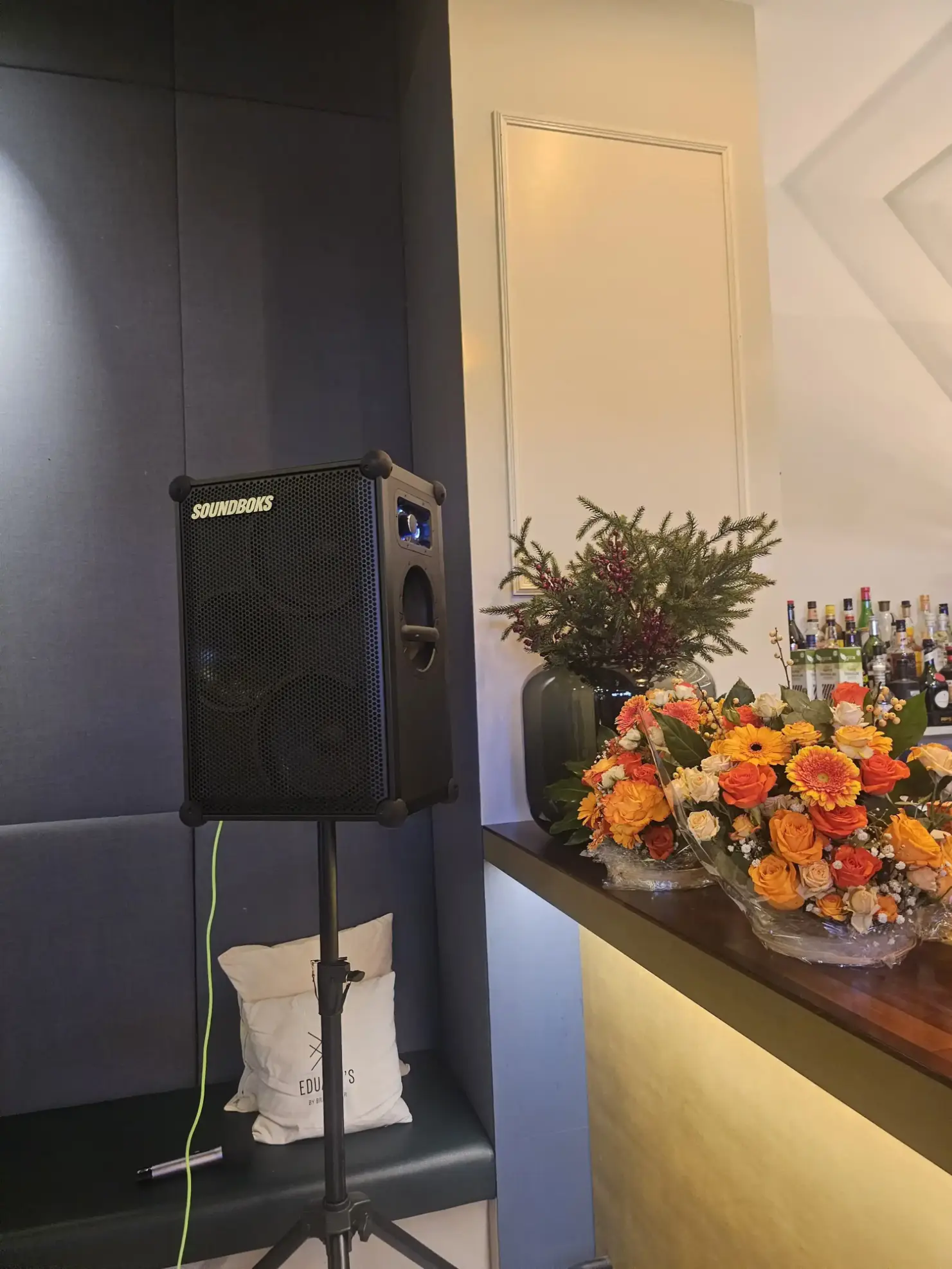 SOUNDBOKS Lautsprecher auf einem Stativ neben Blumengestecken an einer Bar, Lautsprecher mieten in Wieselburg.