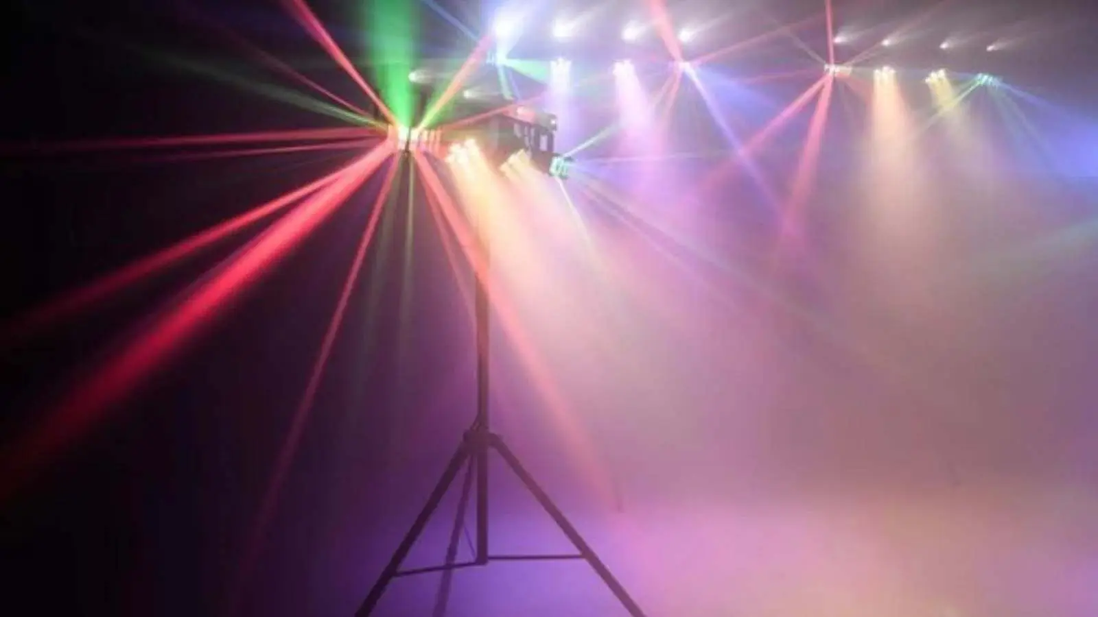 Profi Lichtshow Paket mit Lichteffekt auf Stativ, das bunte Lichtstrahlen und Nebel in einen dunklen Raum wirft.