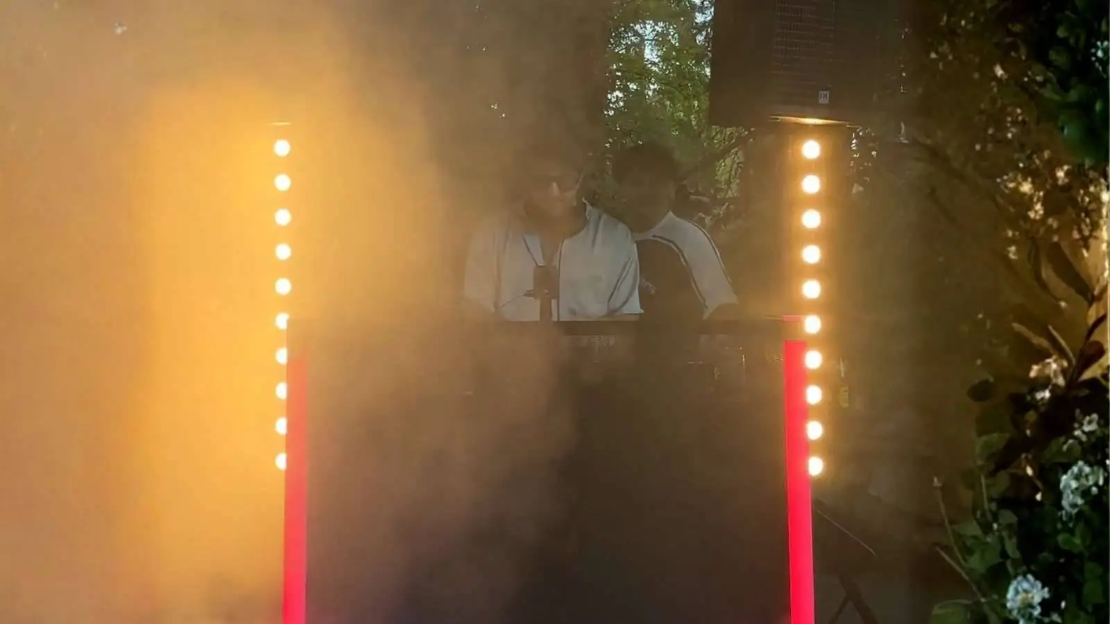 Showtec Sunstrip LED Lichtbalken als warmes Uplight an einem DJ-Pult im Nebel bei einer Abendveranstaltung.