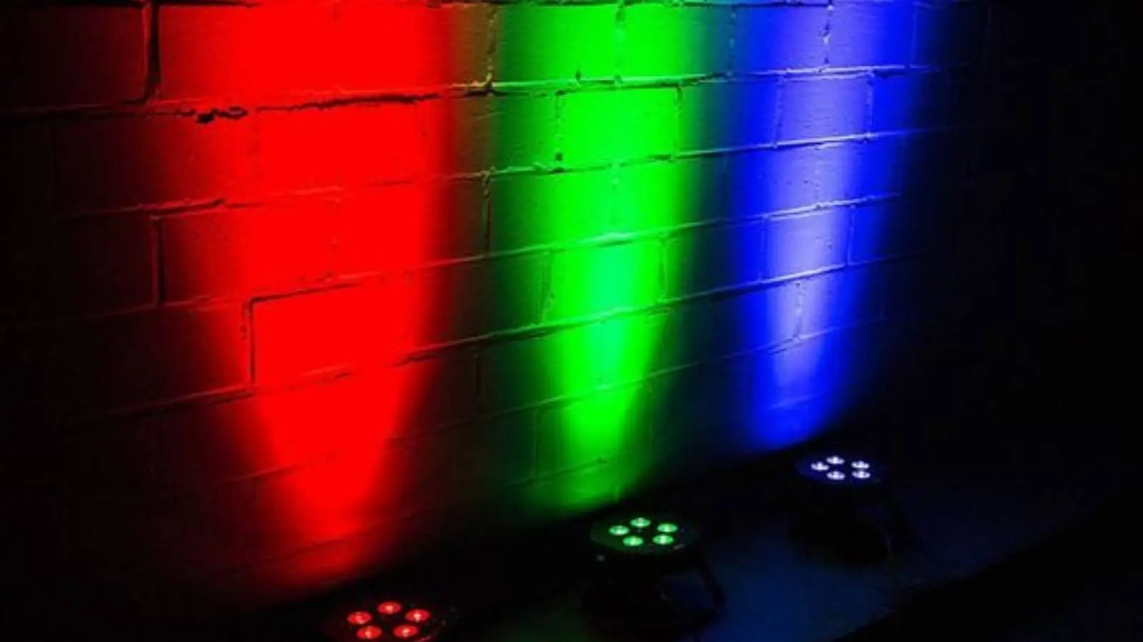 Drei ADJ Mega TriPar Profile Plus LED-Scheinwerfer beleuchten eine Wand in Rot, Grün und Blau.