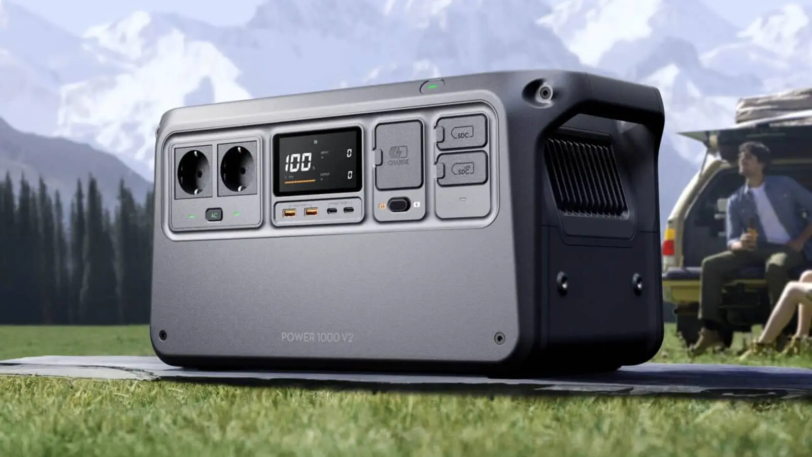 DJI Power 1000 V2 Powerstation im Outdoor-Einsatz auf einer Wiese vor Bergkulisse.