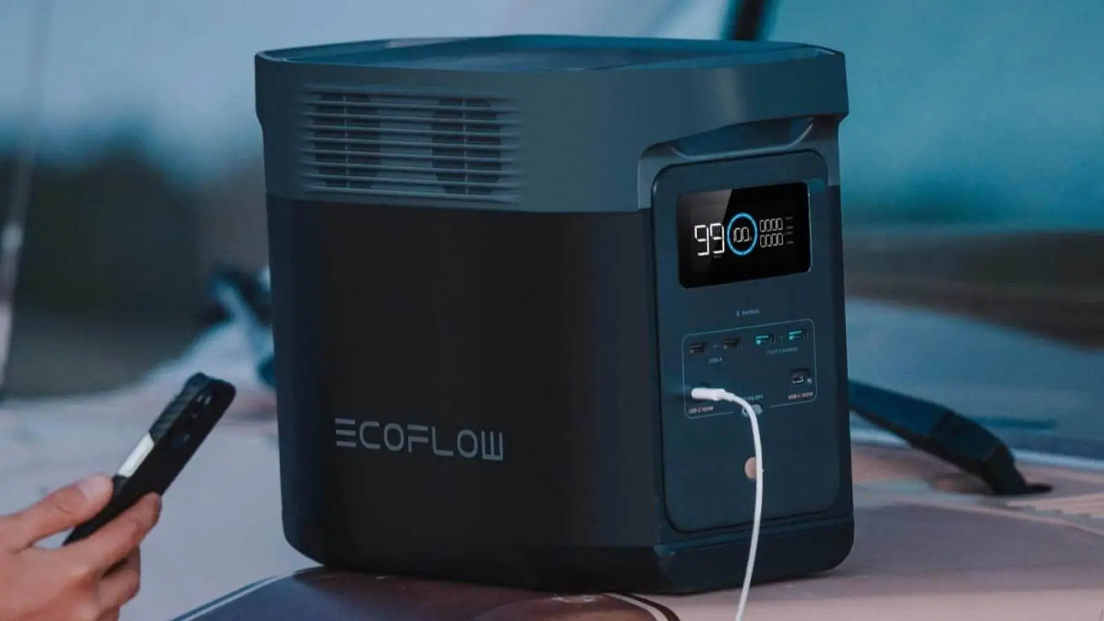 EcoFlow Delta 2 Powerstation beim Aufladen eines Smartphones im Einsatz bei Dämmerung.