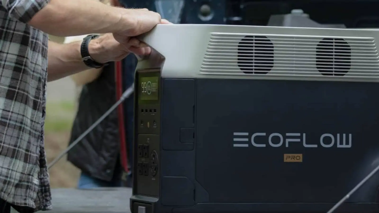 EcoFlow Delta Pro Powerstation im Einsatz, von einer Person am Griff angehoben im Freien.