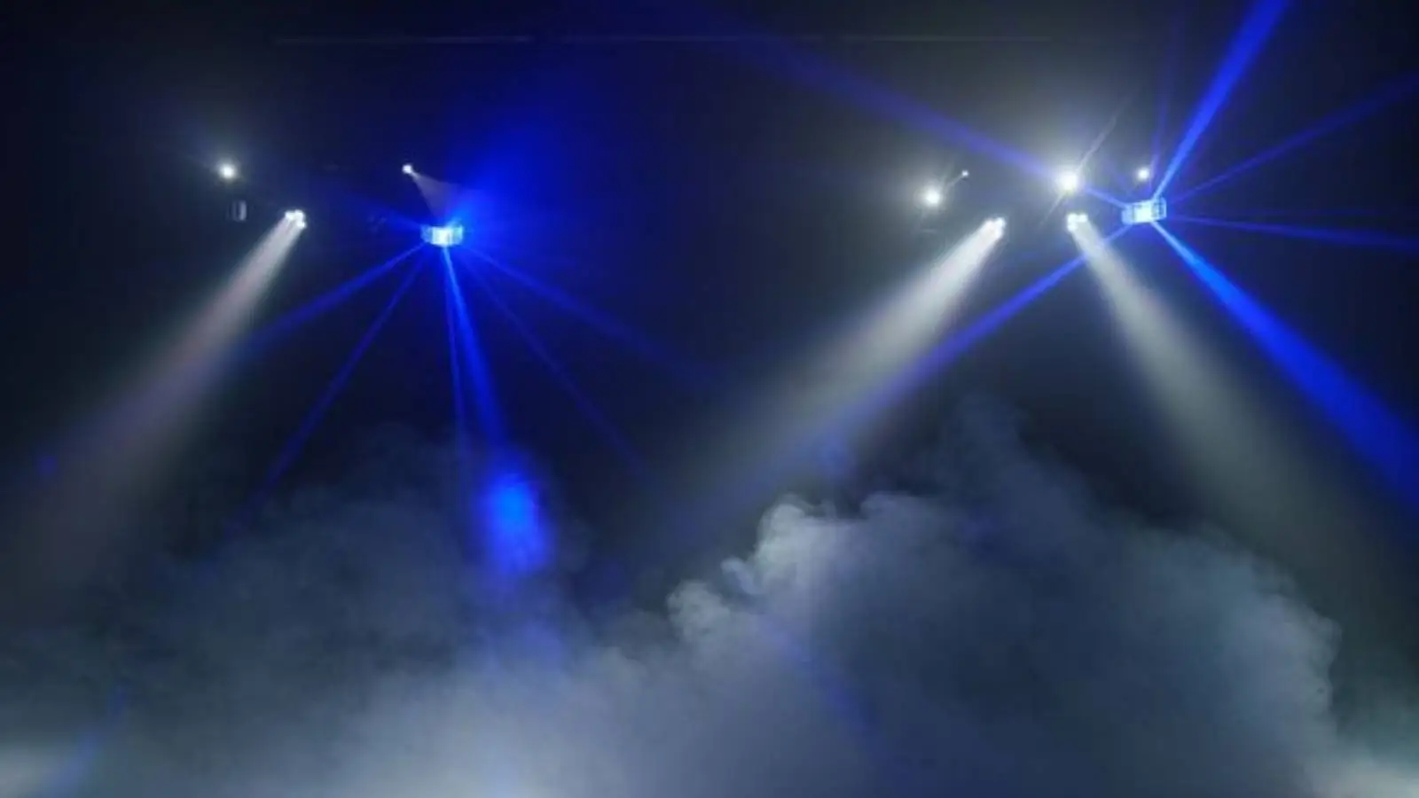 Eurolite LED KLS Laser Bar Pro FX-Set im Einsatz mit blauen und weißen Lichtstrahlen über dichtem Nebel.