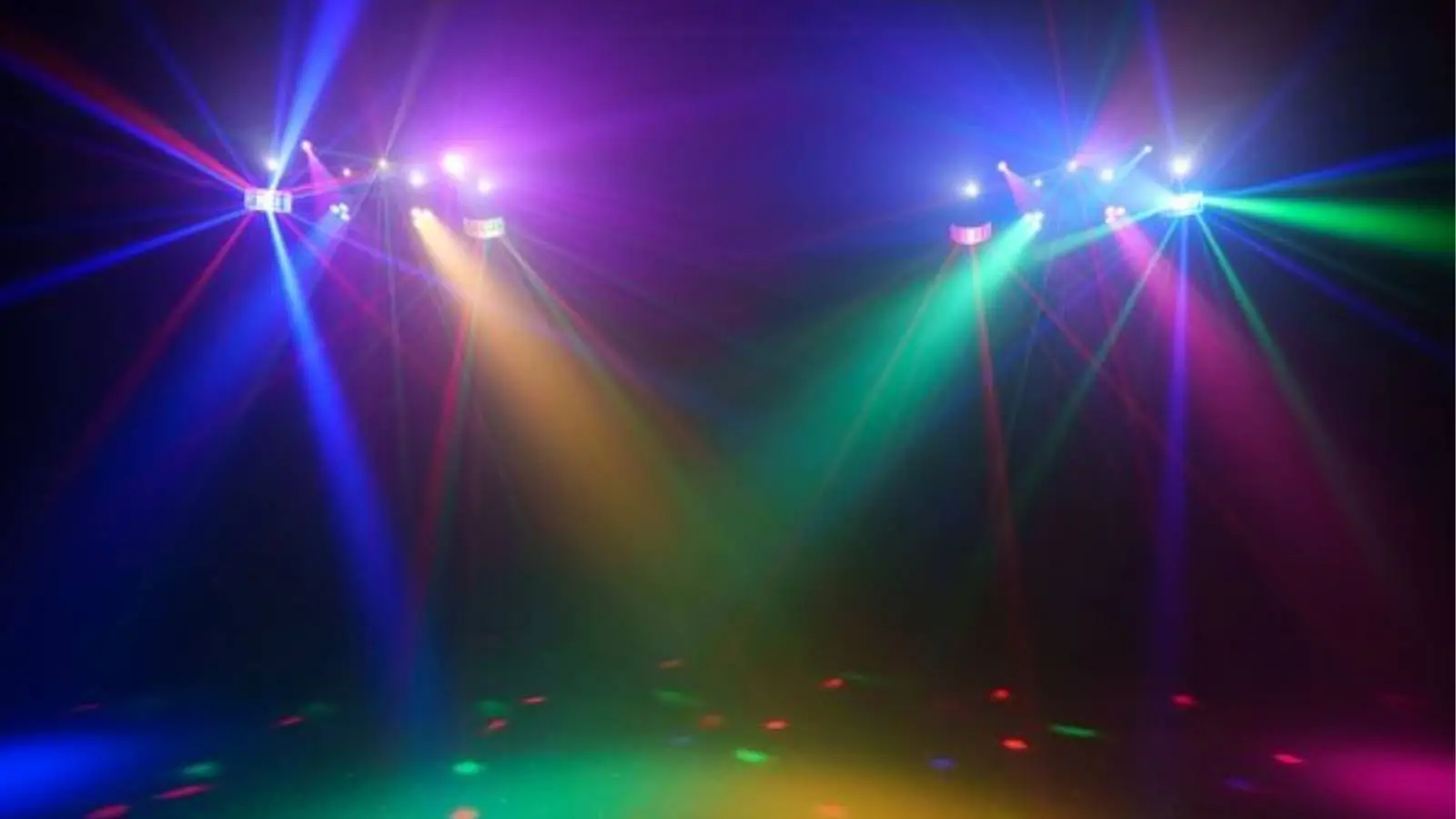 Eurolite LED KLS Laser Bar Pro FX-Set im Einsatz mit bunten Lichtstrahlen in Blau, Grün und Pink auf der Tanzfläche.