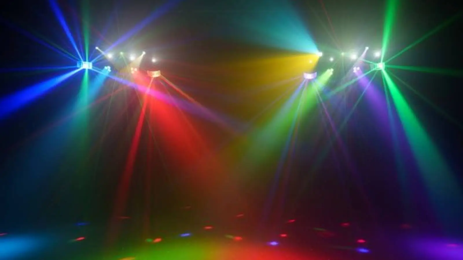 Eurolite LED KLS Laser Bar Pro FX-Set im Einsatz mit farbigen Lichteffekten in Rot, Gelb und Grün im dunklen Raum.