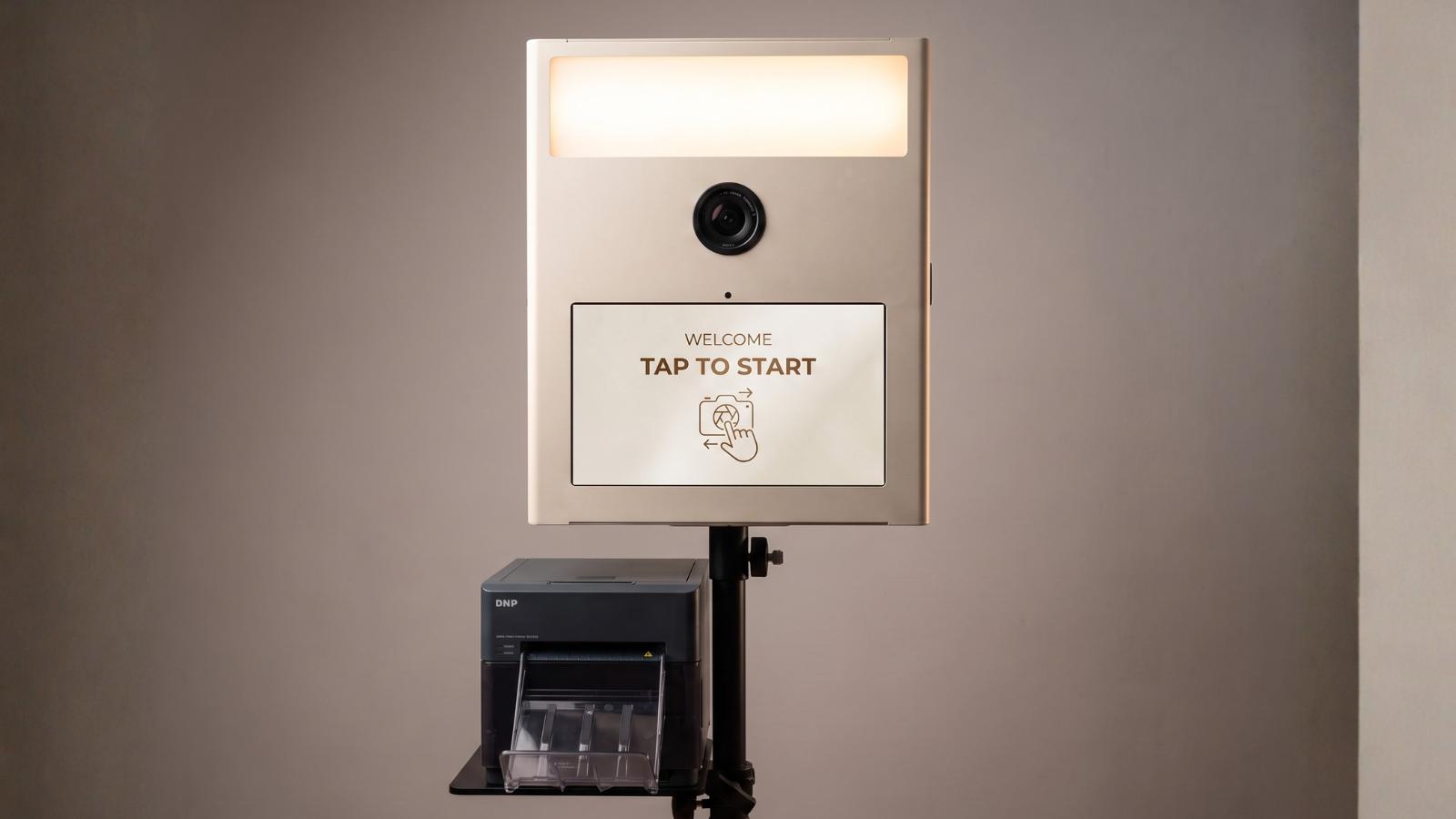 Fotobox Print mit Ringlicht, Touchscreen und DNP-Sofortdrucker in Frontansicht vor grauem Hintergrund.