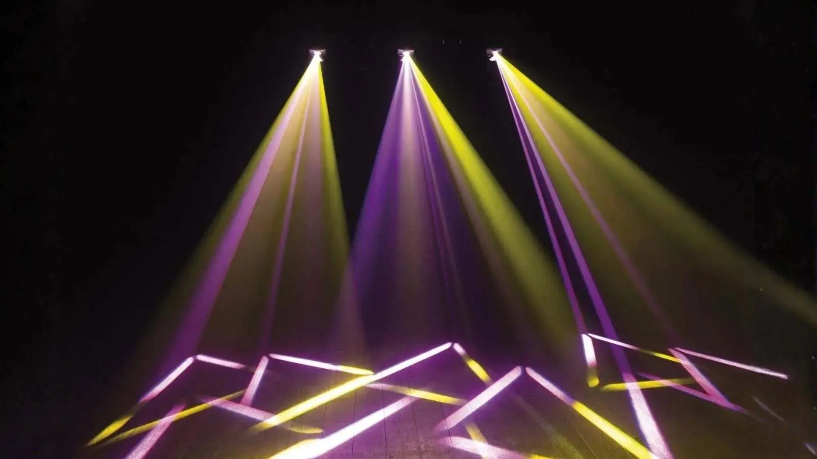 Lichtshow aus dem Profi Lichtshow Paket mit lila und gelben Lichtstrahlen auf dunkler Bühne.