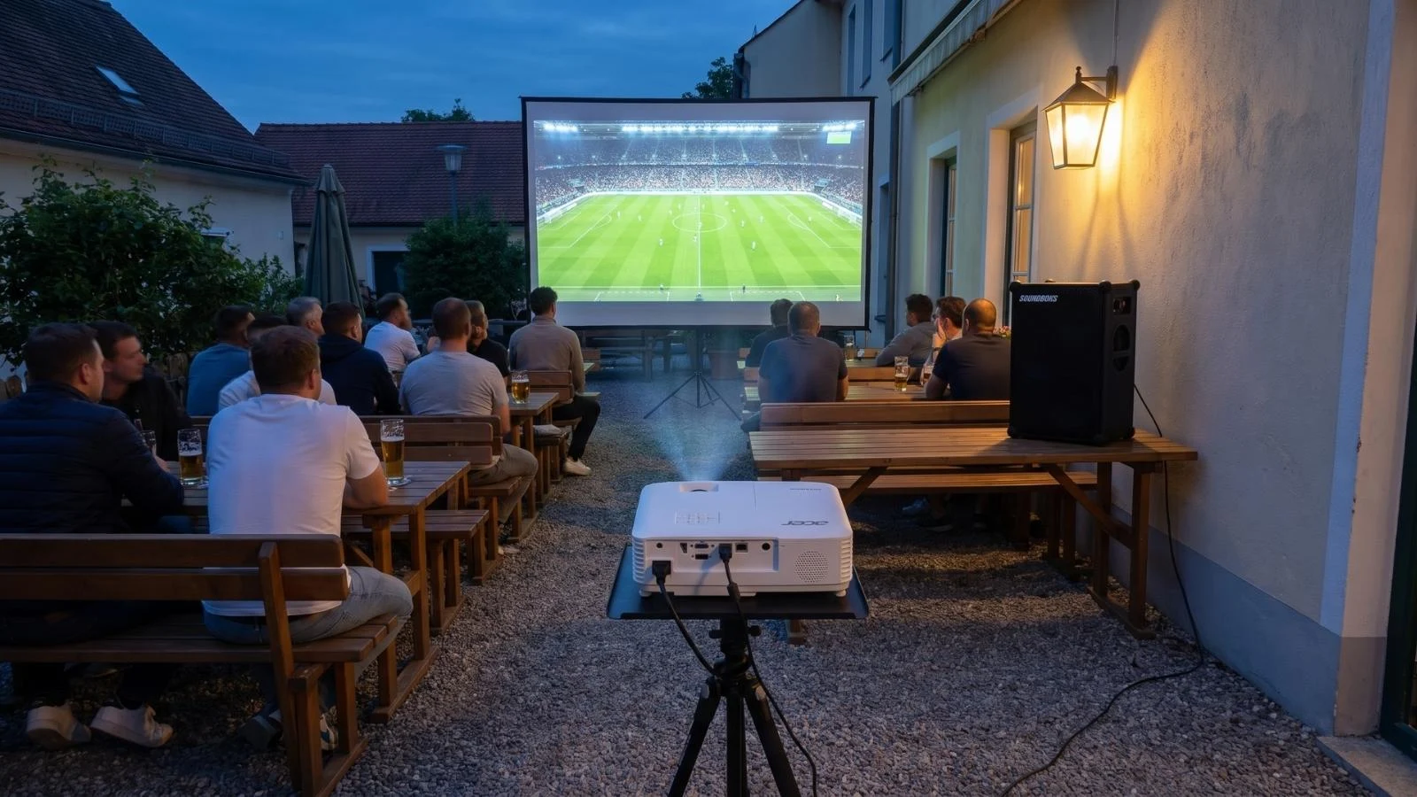 Public Viewing Paket im Außeneinsatz mit Acer Beamer auf Stativ, großer Leinwand und Soundboks beim Fußballabend.