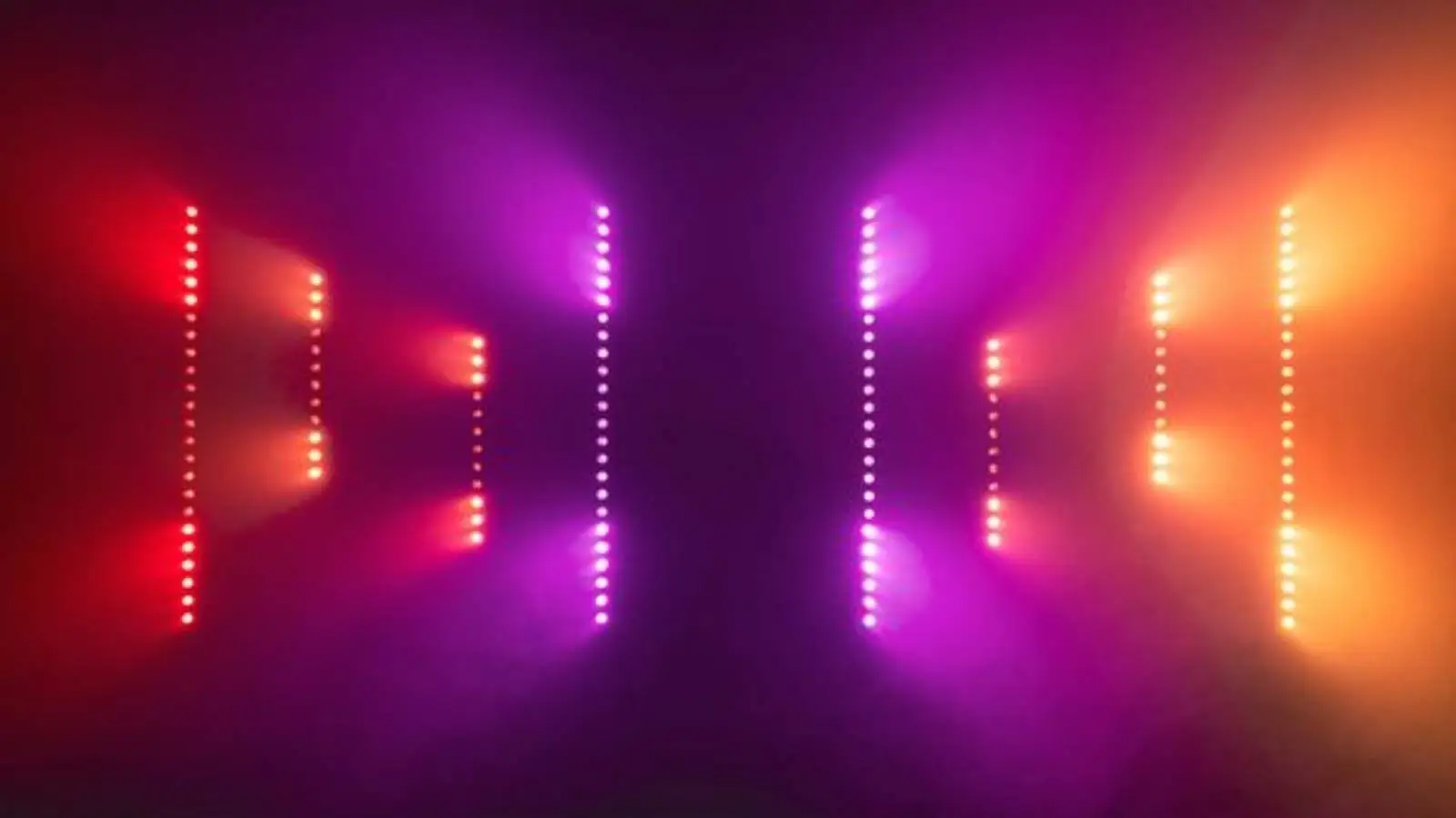 Stairville SonicPulse LED Bar 10 Pixel-Bars mit roten, violetten und orangenen Lichtpunkten im Nebel.