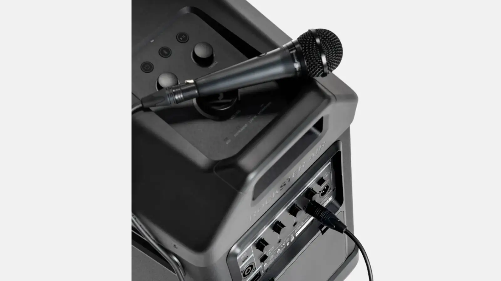 Teufel Rockster Air 2 Akku-Lautsprecher mit angeschlossenem Handmikrofon am Eingang der Oberseite.