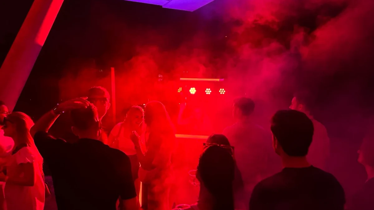 Abiturienten feiern in rotem Partylicht und dichtem Nebel auf der Tanzfläche