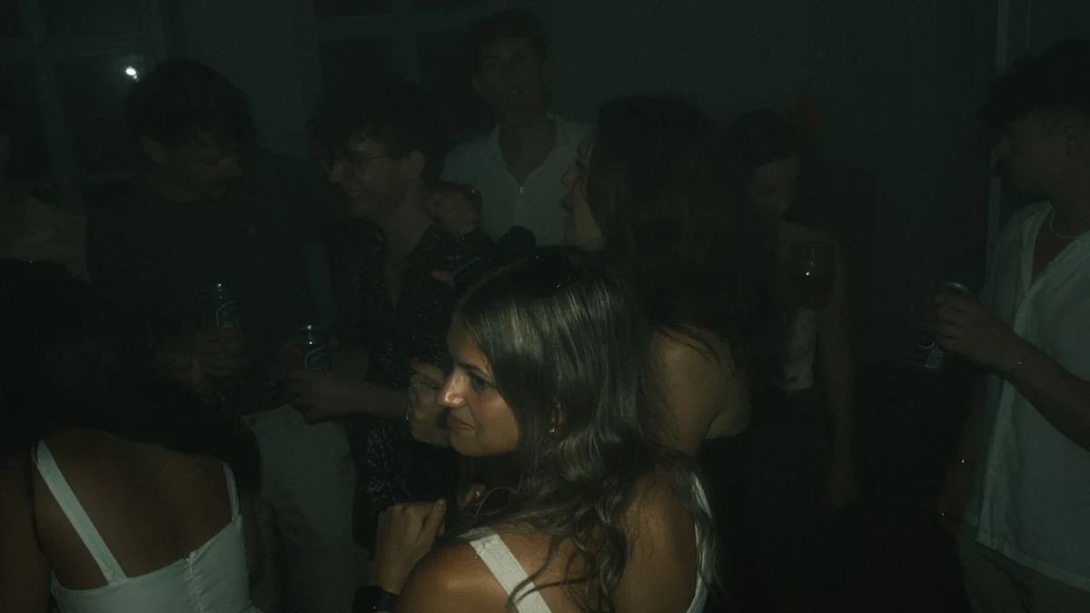 Junge Leute feiern bei einer Hausparty im abgedunkelten Raum