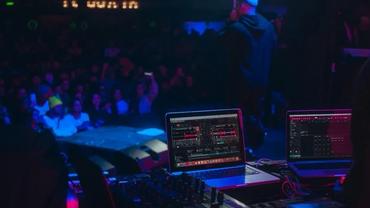 Blick hinter das DJ-Pult auf das Publikum einer oeffentlichen Veranstaltung mit Musik
