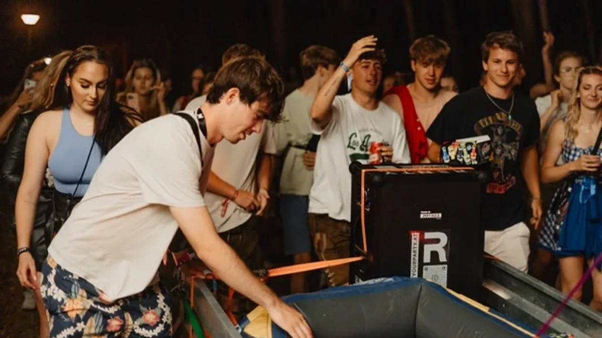 Junge Leute stehen nachts um einen Anhänger voller Getränke auf dem Weg zum Festival