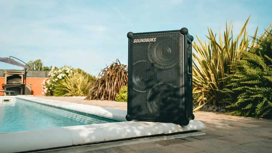 Lautsprecher am Rand eines Pools im Garten als Musikanlage für ein Sommerfest