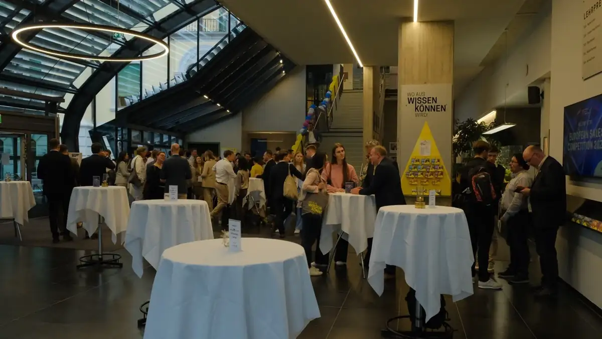 Foyer mit weiß gedeckten Stehtischen und Gästen bei einem Firmenempfang