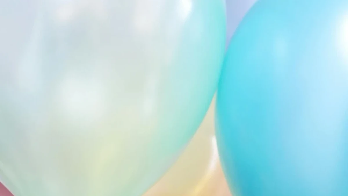 Pastellfarbene Luftballons in Türkis, Blau, Gelb und Rosa mit goldenen Bändern