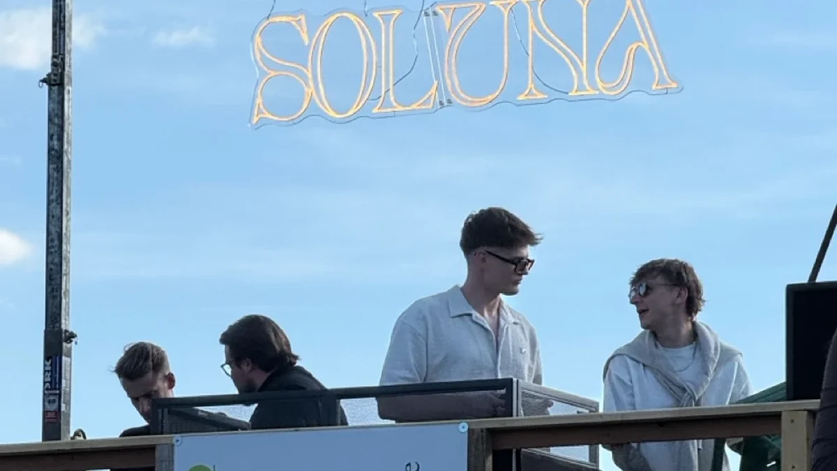 DJs hinter dem Pult einer Open-Air-Bühne mit Moving Heads bei Sonnenuntergang