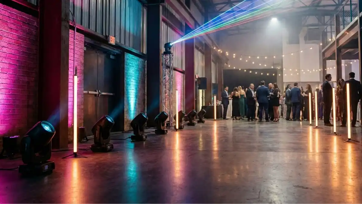 Moving Heads, bunte LED-Tubes und ein Laserstrahl beleuchten eine Halle bei einer Feier