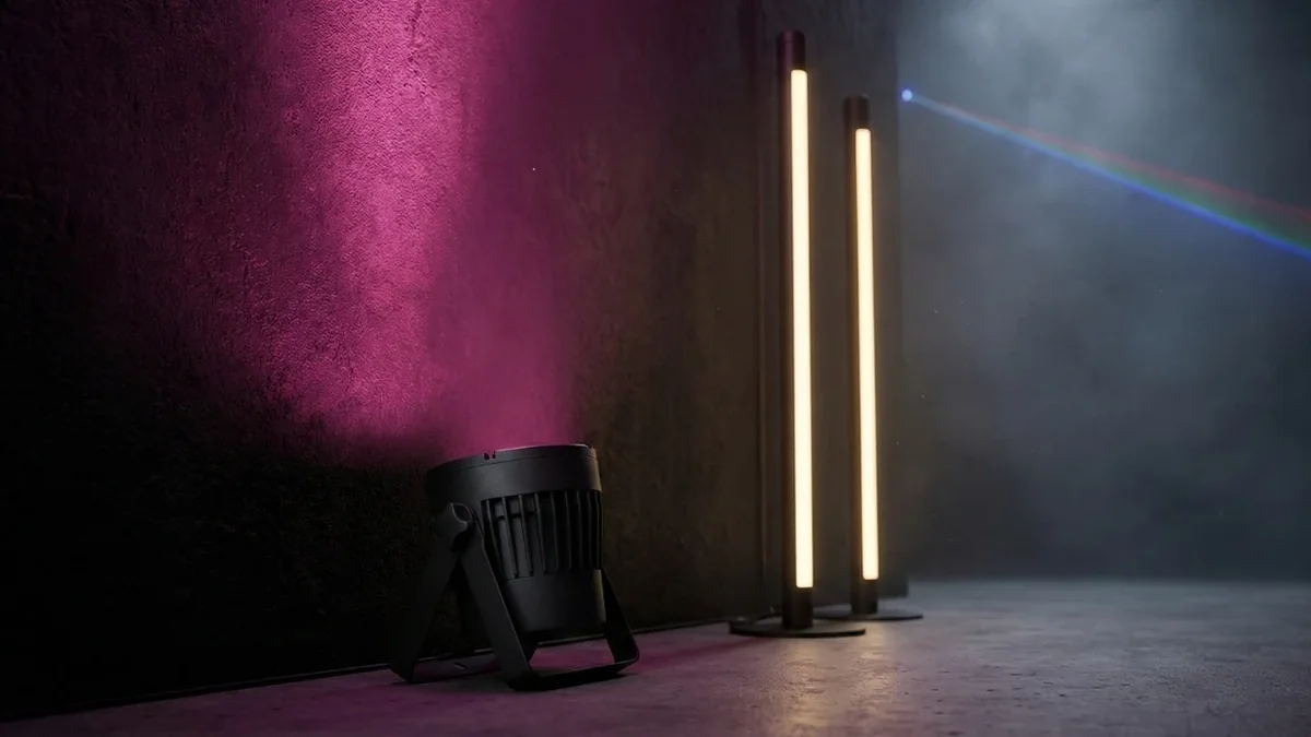 LED-Scheinwerfer taucht eine Wand in Magenta, daneben warmweiß leuchtende LED-Tubes