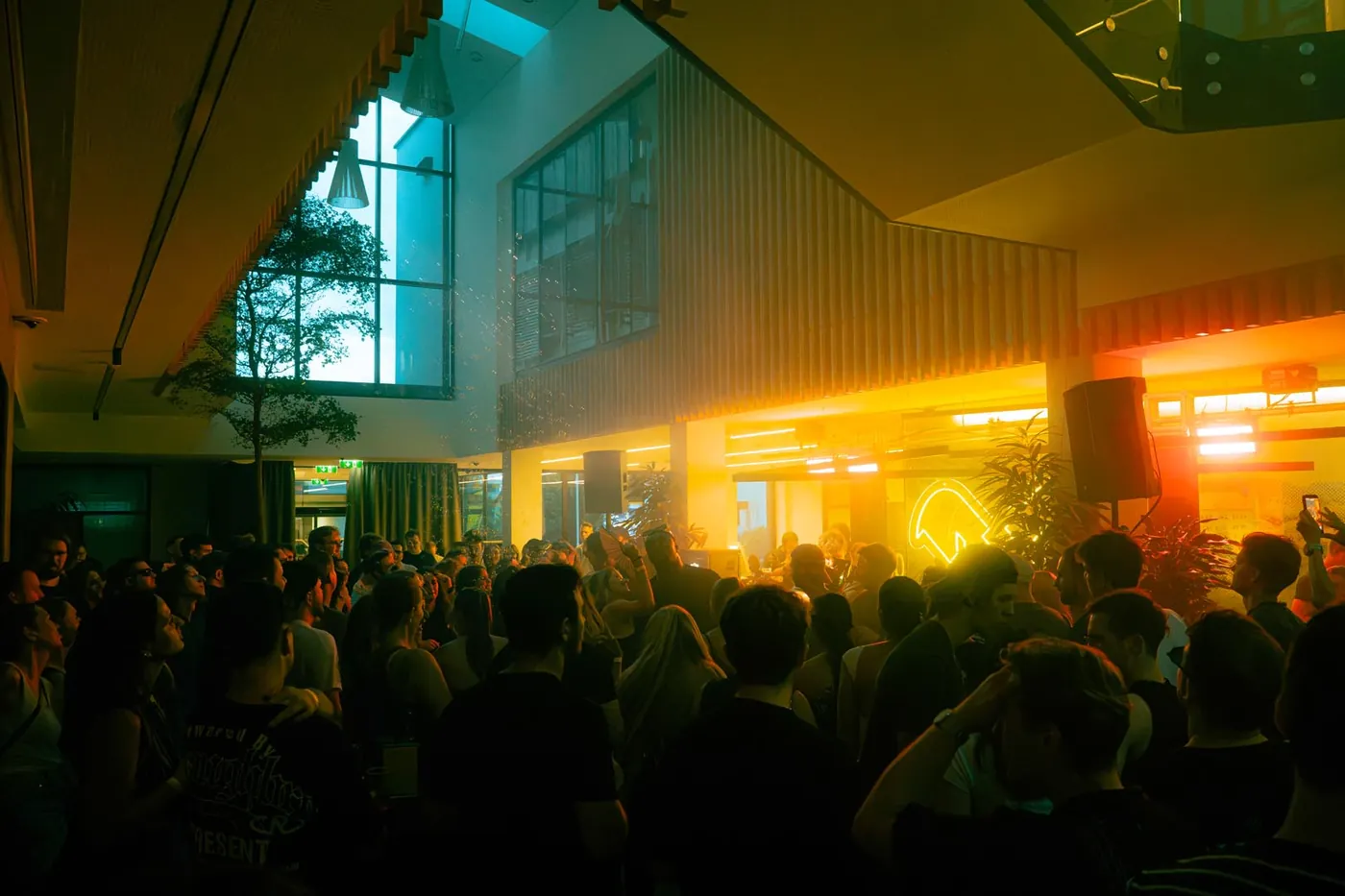 Tanzfläche in der Schalterhalle der Raiffeisenbank Graz beim Rave Eisen, Glasdach und Lautsprecher auf Stativ