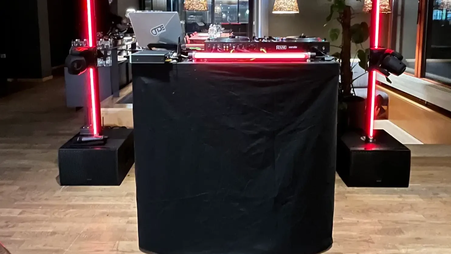 DJ-Tisch mit schwarzer Husse und LED-Säulen bei einer Abendveranstaltung