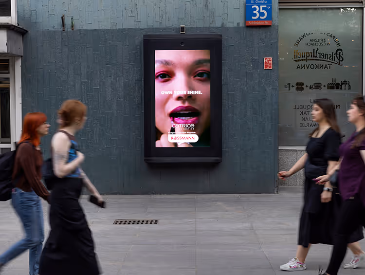 4 girls walk past a makeup digital poster advert