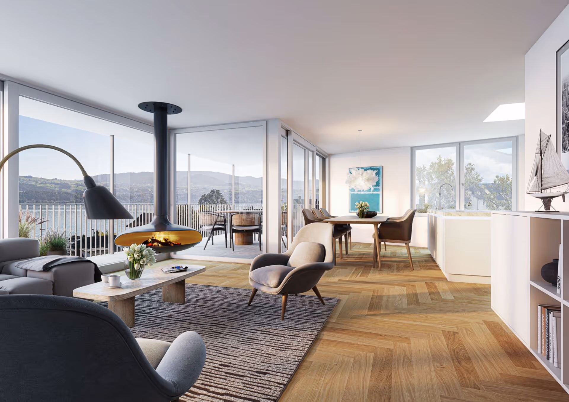 Modern open living room with gray armchairs, a hanging fireplace, wooden coffee table, adjacent dining area, and large windows overlooking a lakeside view.
