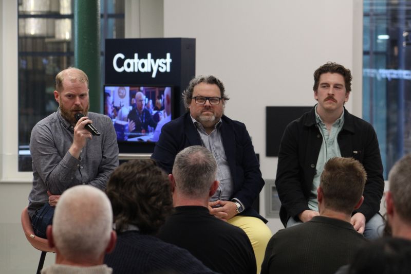 Martin Naughton and two fellow panellists facing the audience at Catalyst.