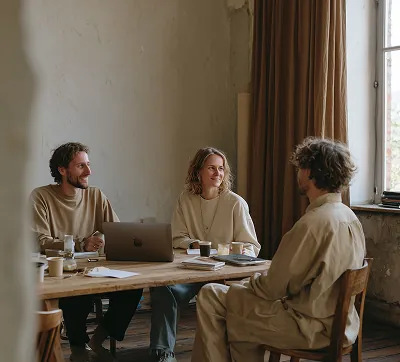 A team of three architects discussing design plans, illustrating collaboration and expert project planning in modern architecture.