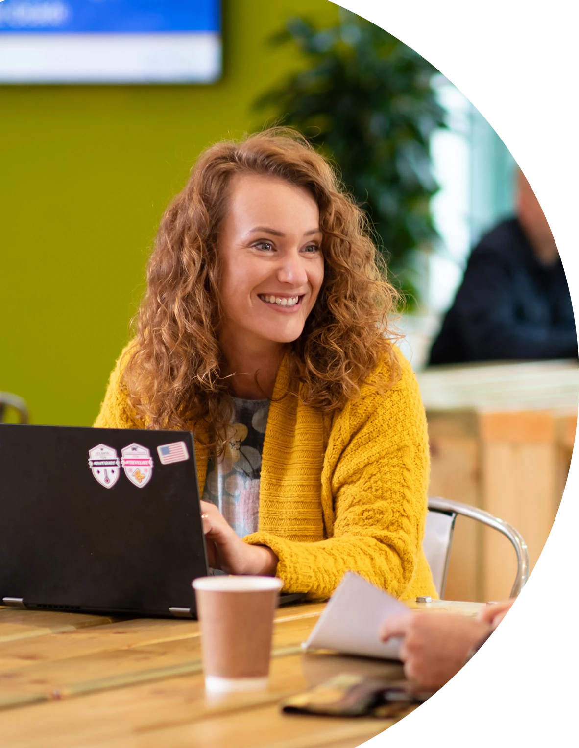 a woman smiling at a laptop