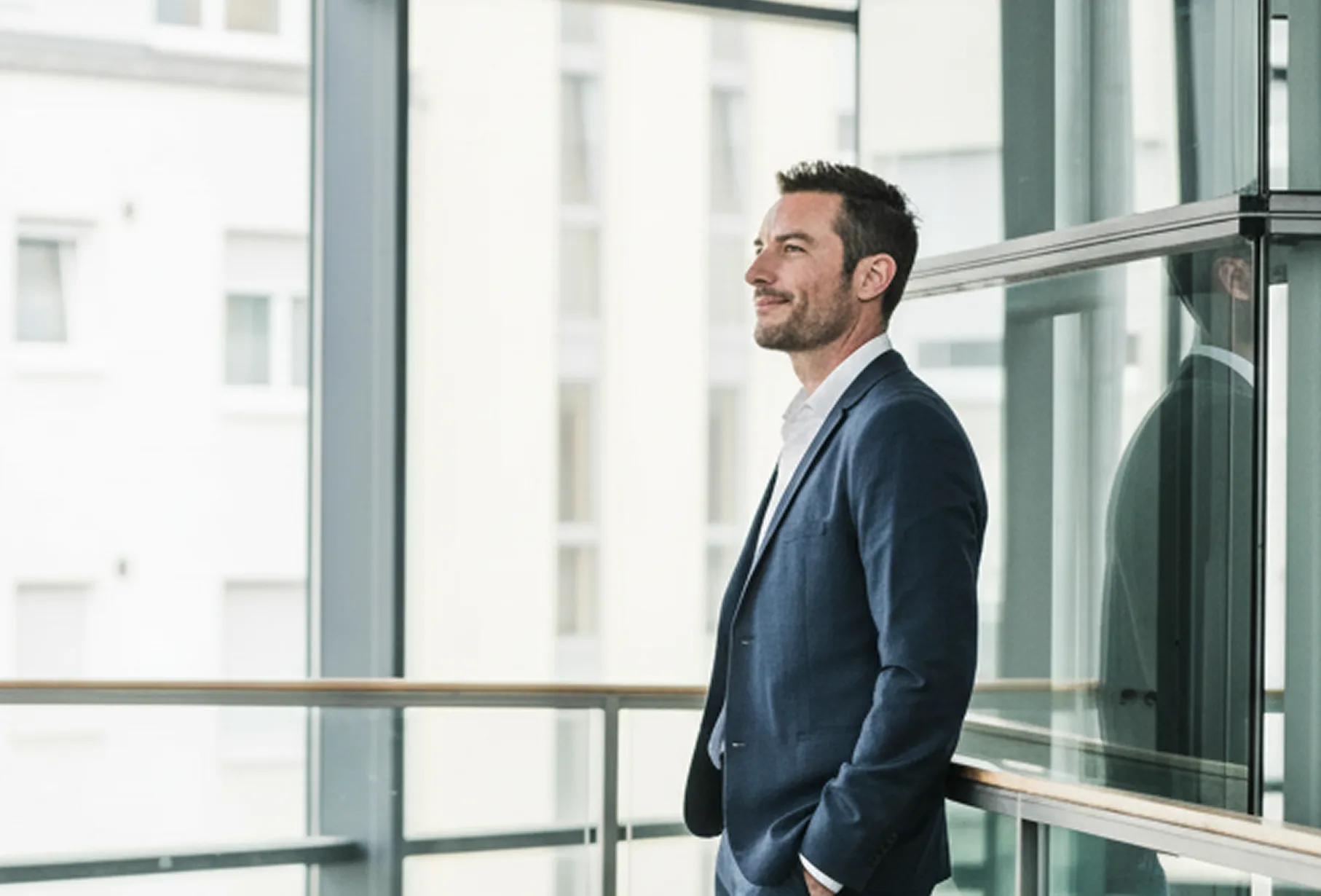 Businesswoman presenting financial bar chart and data on screen to three colleagues seated at conference table.