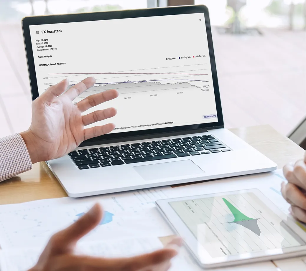 Man wearing glasses explaining a point during a meeting with a laptop and documents on the table.
