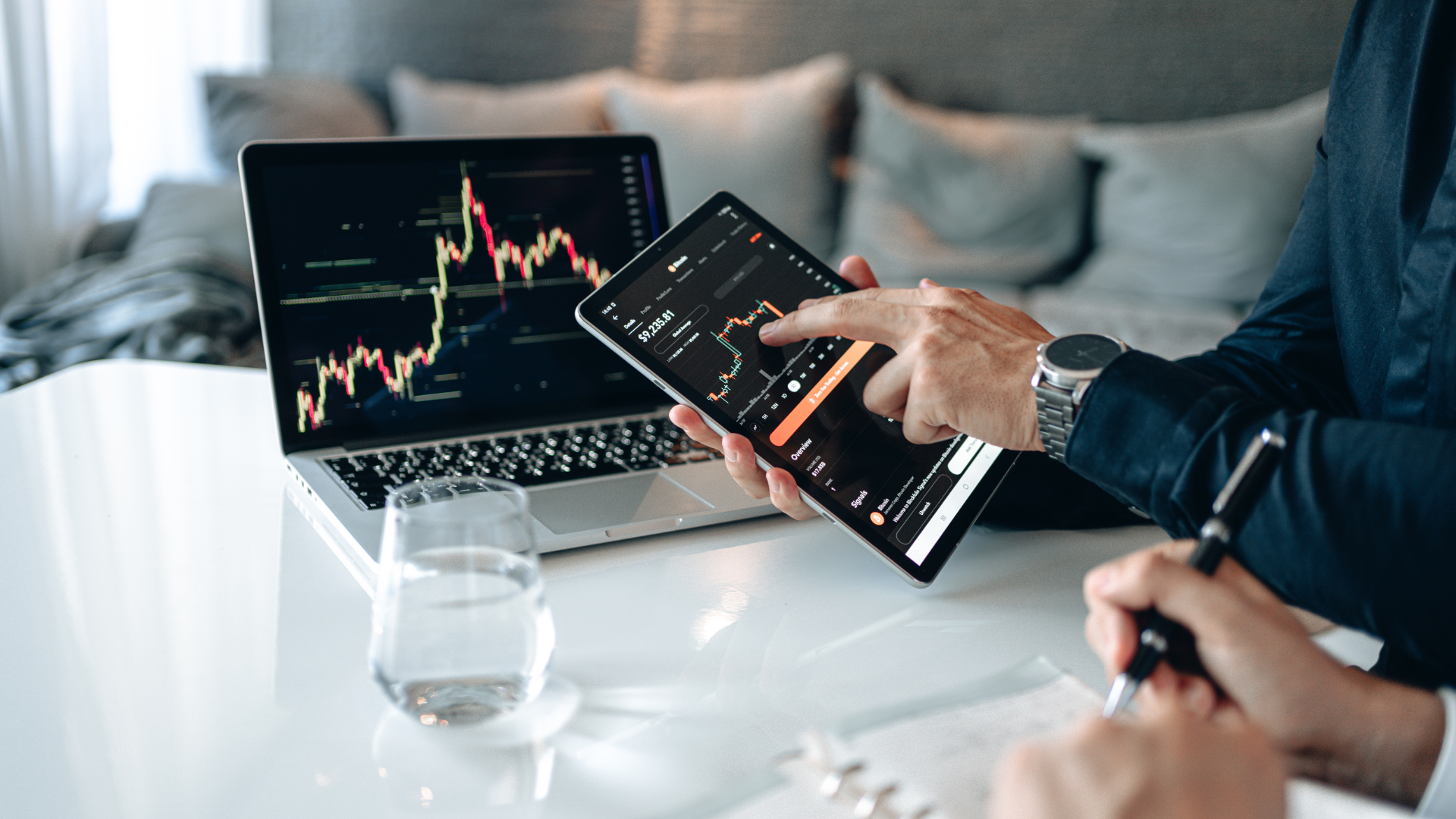 Image depicting forex candle charts on a phone and laptop 
