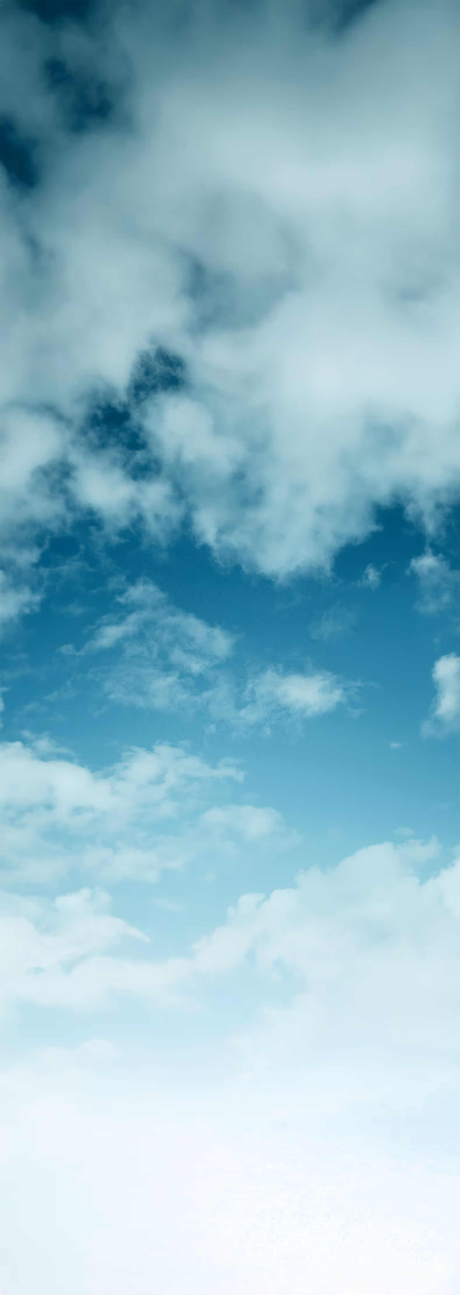 Blue sky with scattered white clouds and a gradient from dark to light blue.