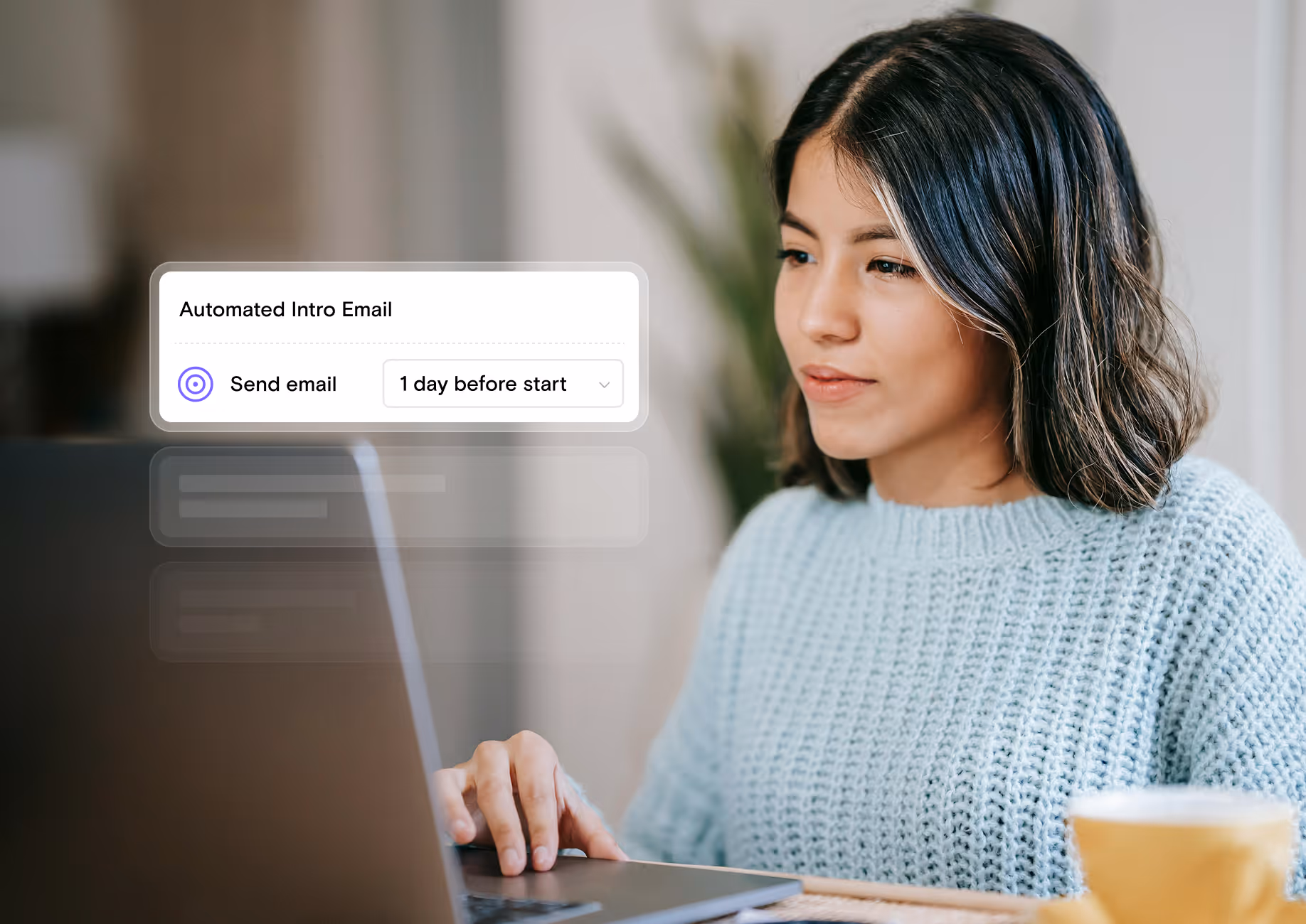Woman in a light blue sweater using a laptop with an overlay showing 'Automated Intro Email' and 'Send email 1 day before start' option.