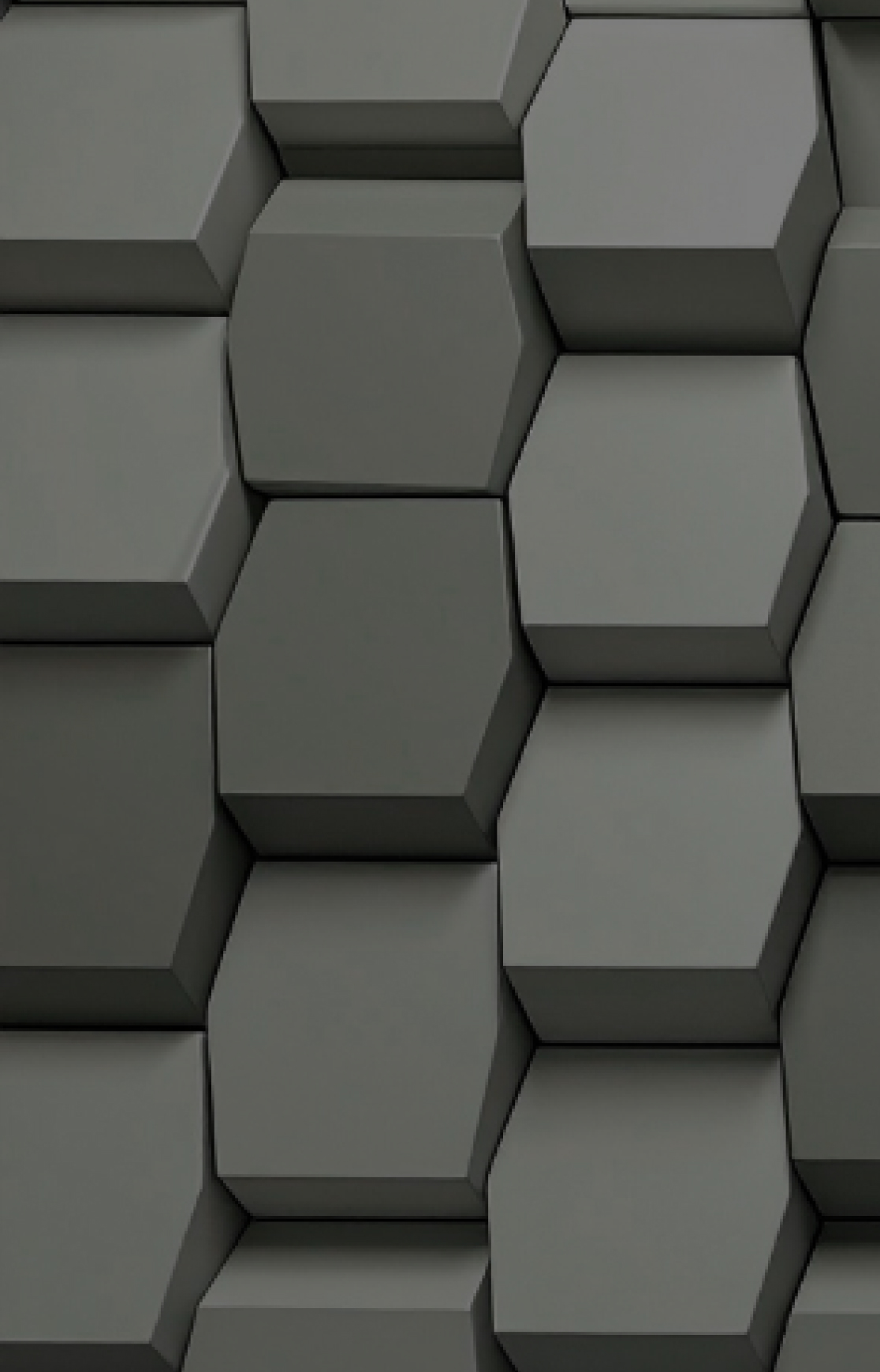Close-up of a pattern of gray three-dimensional hexagonal blocks arranged in a honeycomb-like structure.