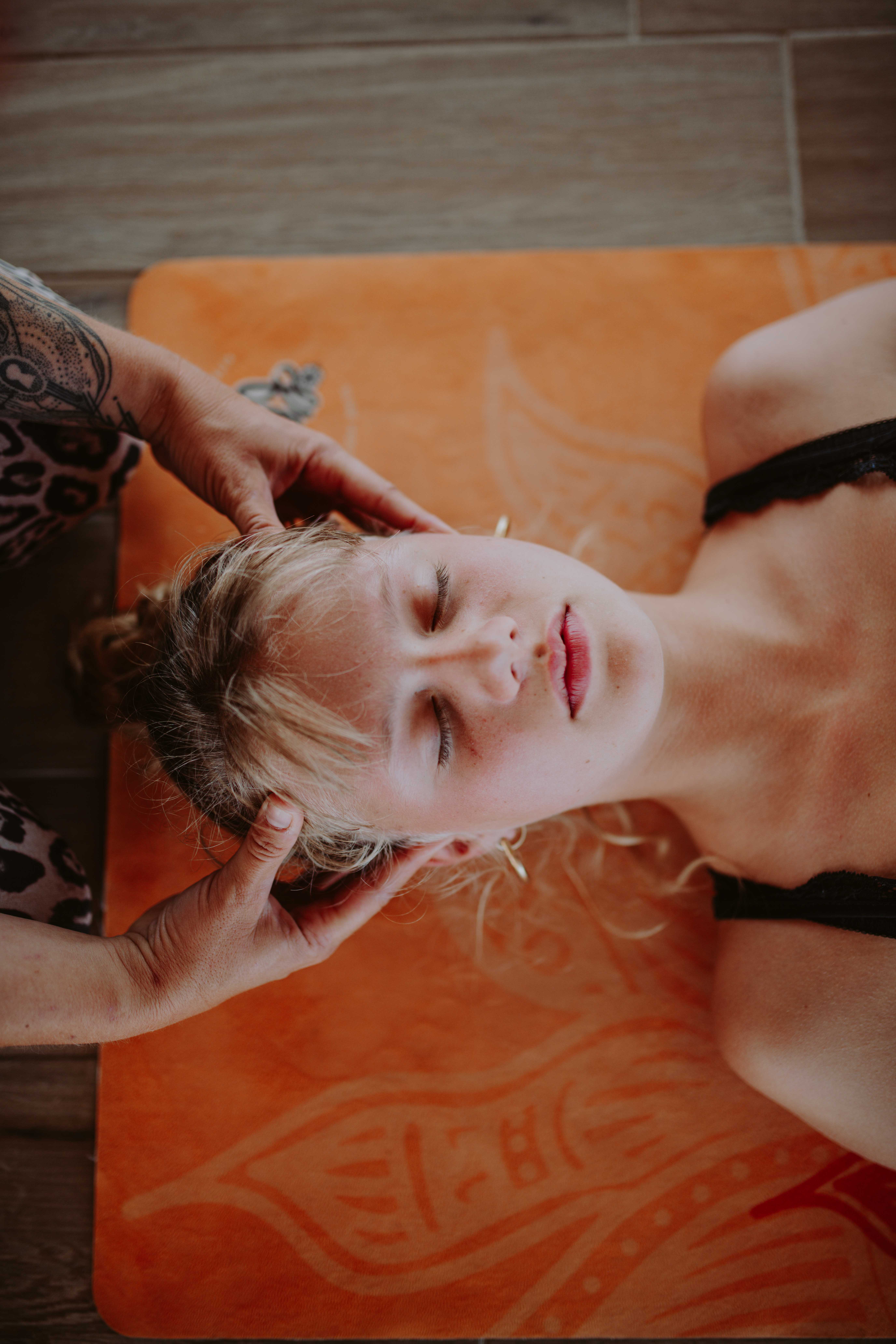 Woman receiving a relaxing head massage at Floripa Yoga and Surf Retreat in Sicily, promoting holistic wellbeing and relaxation