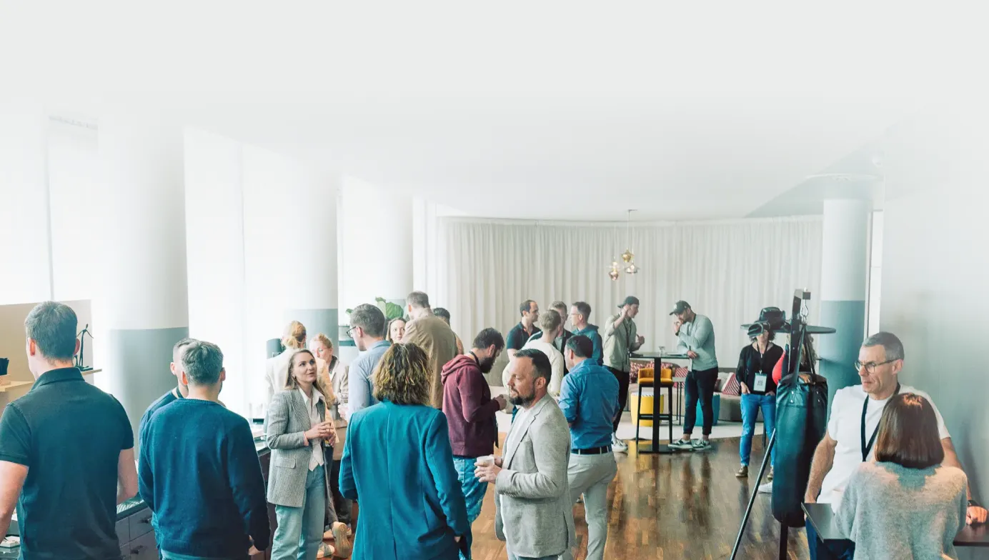 Menschen unterhalten sich in einem hellen Raum während einer informellen Networking-Veranstaltung.